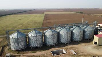 Grain elevator. Metal grain elevator in agricultural zone. Agriculture storage for harvest. Grain elevators on green nature background. Exterior of agricultural factory. Nobody. video