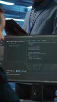 vertical gerente supervisando equipo y haciendo sistema análisis de servidor granja supercomputadoras utilizando tableta. hombre supervisando empleados en datos centrar alojamiento almacenamiento infraestructura secundario crítico eso cargas de trabajo video