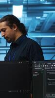 Vertical Developer in server hub using laptop to present manager plan of repairing equipment storing datasets. Specialist uses notebook to explain team leader ways of fixing rigs doing computational operations video