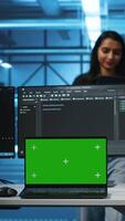 verticaal leidinggevende in server hub beheren verschillend team van ontwikkelaars gebruik makend van groen scherm laptop op zoek voor verkeerde configuraties. manager coördineren experts herstellen gegevens centrum bugs met chroma sleutel notitieboekje video