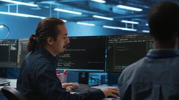 Engineers coding together in high tech server hub, using computers to analyze data, ensuring seamless data flow. Colleagues examining infrastructure in data center, ensuring system integrity and security video