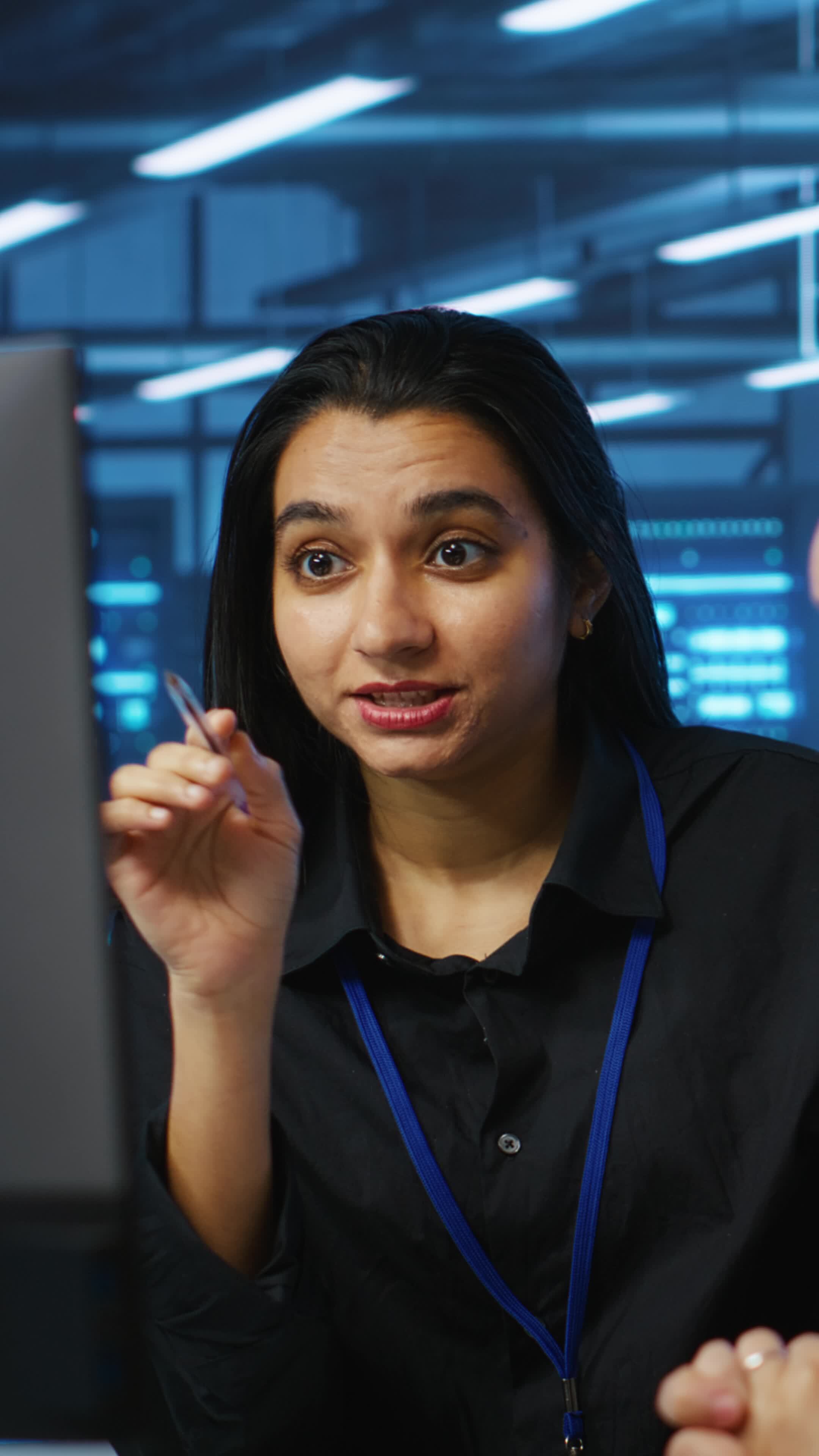Vertical Programmers talking in high tech server hub, using PCs to ...