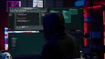 Experienced hacker writing lines of code on computer from underground bunker, tying to get past security systems. Rogue programmer building scripts that can hack devices, camera A video