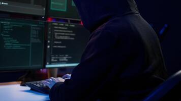 perigoso homem hackear, roubando crédito cartão números e infiltrando bancário sistemas, portátil Câmera tomada. fechar acima do hacker corrida código dentro apartamento em pc monitores, Câmera b video