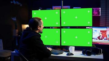 Cybercriminal coding on green screen monitors, developing zero day exploit undetectable by antivirus software. Hacker using mockup PC displays to build script tricking firewalls, camera B video