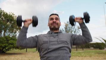 italiano hombre lo hace hacia arriba empuja con pesas en al aire libre Corte video