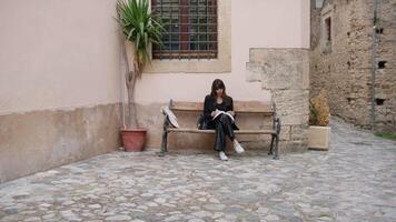 fille séance sur le banc de le Hamlet lit une livre video