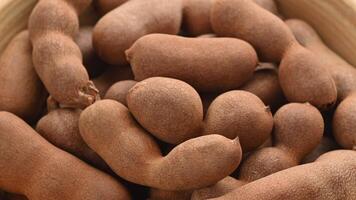 Closeup of a heap of tamarind fruit pods rotating on the turntable. video