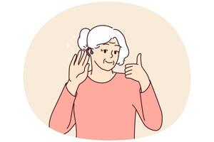 Elderly woman uses hearing aid and shows thumbs up confirming good sound volume thanks to new device vector