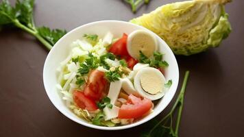 färsk vegetabiliska sallad, kål, tomater i en skål på en trä- tabell video