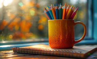 Colored pencils and notebook on the window photo