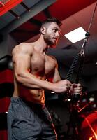 Strong handsome man doing exercises. Shirtless young man with good physique. photo