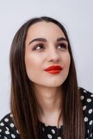 Portrait of beautiful woman with juicy red lips smiling while looking away during the posing at the studio. Isolated on white background photo