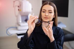 Portrait of optician client choosing prescription glasses. New modern glasses with diopters. Pretty woman with spectacles. photo