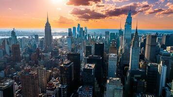 Orange light of setting sun illuminating the skyscrapers and high-rise buildings in New York scenery. Top view on the metropolis from above the East River. photo