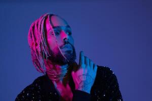 Neon light studio close-up portrait handsome black gay man looking camera. photo