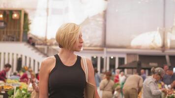 Woman looking at vegetable stalls while walking at market during daytime video