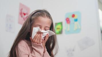 Sick girl sneezing snot into tissue paper in bedroom at home video