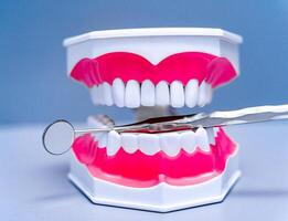 estomatología y dental tratamiento concepto. anatómico modelo de dientes y médico dispositivos en el del dentista mesa. cerca arriba. foto