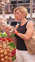 Frau Kauf Knoblauch beim Stall auf Markt während tagsüber video