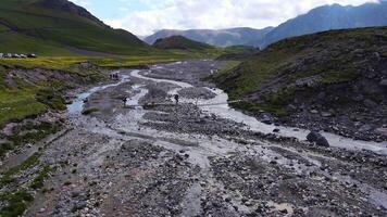 zangão Visão do turistas cruzando a rio em a caminho para montar Elbrus norte video