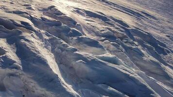 Aerial. Sunset over snowy mountain with icy crevasses video