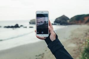 Crozon, France 29 May 2018 Woman tourist taking photo with smart phone on the nature