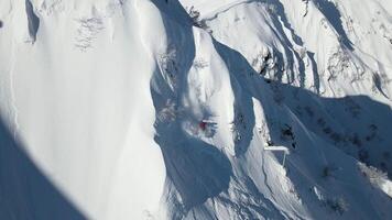 aéreo. esquiador desciende un empinado, desprevenido Pendiente después un nevada video