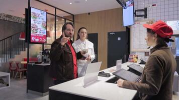 Warszawa polen oss 10.05.2024 beställning på en snabb mat disken kfc, en man och en kvinna är placering ett beställa på en snabb mat disken, interagera med de kassör. video