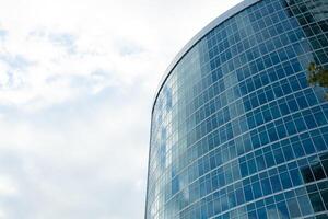 Detail blue glass building background with cloud sky photo