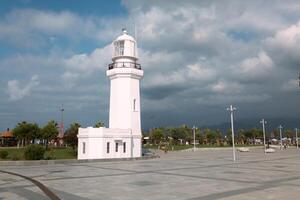 Batumi, Georgia 29 August 2018 White Lighthouse with cloud sky on the background photo