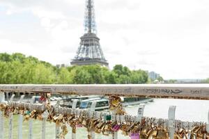 Paris, France, Europe - June 02, 2018 Padlocks on the Arts Bridge over the Seine River in Paris With Eifel tower on the background photo