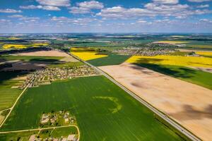 top view of a sown green field and a small village in Belarus. Agricultural fields in the village.Spring sowing in a small village photo