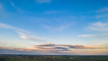 Green meadow under a blue sunset sky with clouds photo