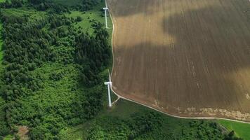 Top view of windmills standing with field and forest. Spinning windmills in the fields of Belarus.Energy photo