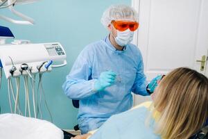 The patient treats her teeth at the dentist in the dental office . Dental fillings photo