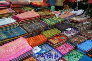 Close up stacks of colorful Sinhs or Sarong, Laos skirt fabric photo