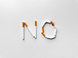 palabra 'No' hecho desde roto cigarrillos en blanco fondo, simbolizando de fumar cesación y anti tabaco mensaje. No tabaco día. foto