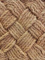 Close up of interwoven natural jute ropes creating textured pattern for rustic backgrounds and sustainable material concept. photo