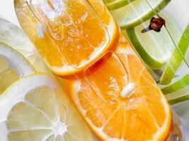 Close up view of fresh orange and lime slices in bottled water, creating refreshing summer detox drinks concept. photo