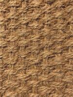 Close up of interwoven natural jute ropes creating textured pattern for rustic backgrounds and sustainable material concept. photo