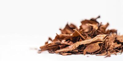 Dried tobacco leaves pile with shallow depth of field on white background with empty space for text. Depicting raw material for cigarettes and cigars. Ai generation. photo