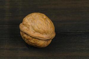 Single walnut on a dark brown table. photo