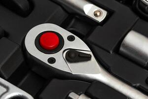 Chrome vanadium steel ratchet wrench with switch and red button in tool box. photo