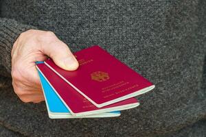 Male hand holds out two German passports. photo