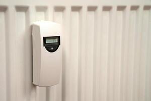 Heat consumption meter on the white radiator. photo