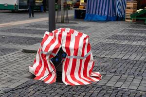 Street electricity distributor covered with red and white striped tarpaulin. photo