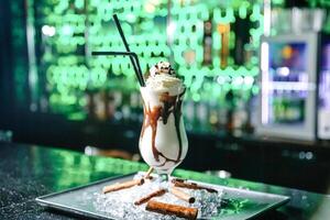 Delicious Chocolate Milkshake With Straw on Plate photo