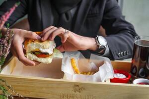 Person Holding a Sandwich in a Wooden Box photo