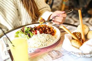 Woman Eating Plate of Food at Restaurant photo